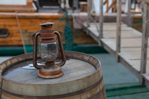 istock Kerosene Lamp on wooden barrel near old ship 1164775302