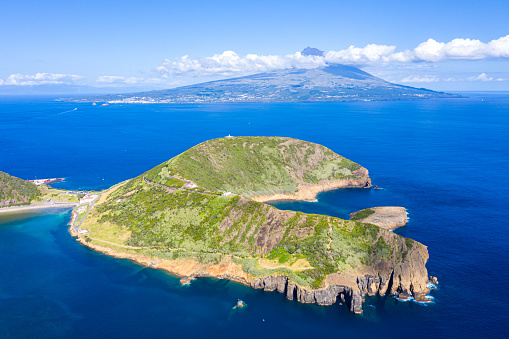 Nature Park of destructed extinct volcano craters of Caldeirinhas, mount Guia near Horta city, Faial island with the peak of Pico volcanic mountain and island in the background, Azores, Portugal.