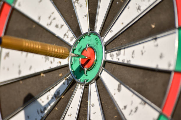 jogo de dardos típico com dardo no bulls-eye. - bulls eye dart target dartboard - fotografias e filmes do acervo