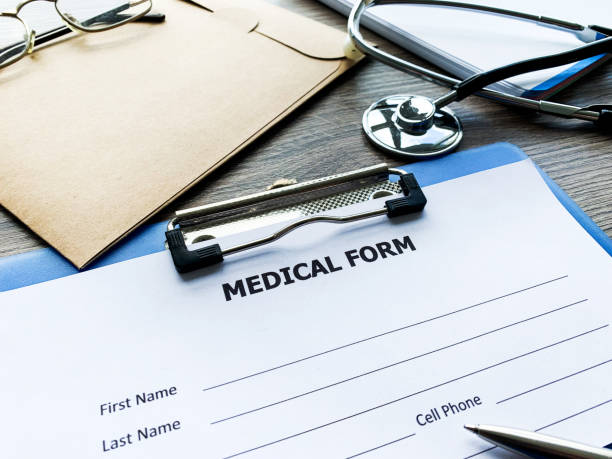 istock Medical form with patient data on doctor's desk 1164779432