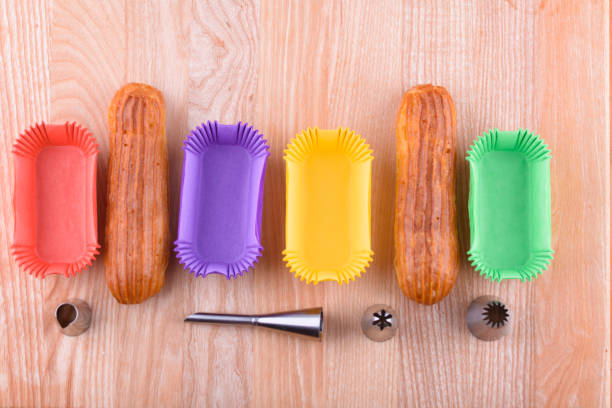 Tasty and beautiful eclairs on a wooden board. Appetizing dessert. Party supplies