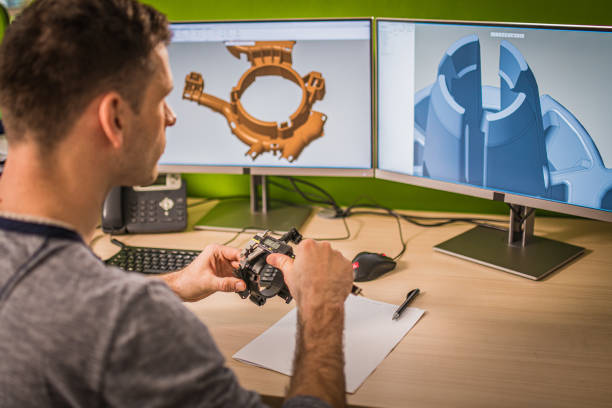 Engineer examining machine part while making a 3D model of it Engineer holding a machine part while making a 3D model on the computer. computer aided design stock pictures, royalty-free photos & images