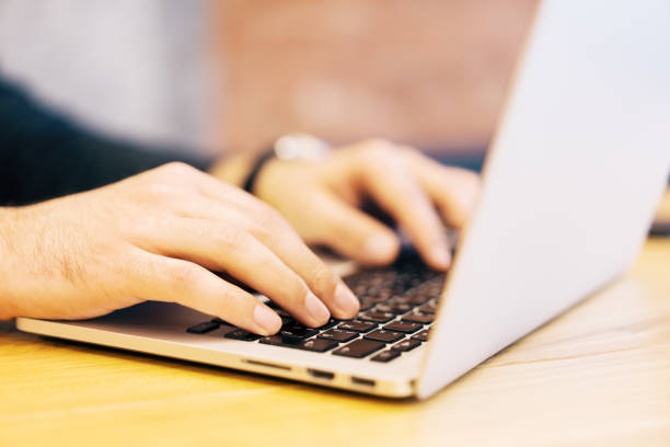 istock Sideview of businessman using laptop on desktop 1164781607