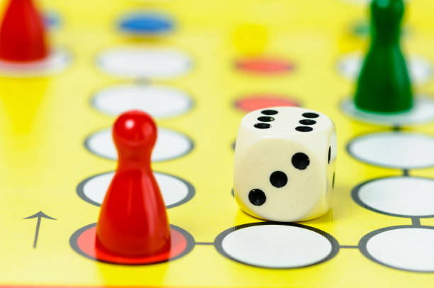 istock Pieces and a die on a Ludo board game 1164790585