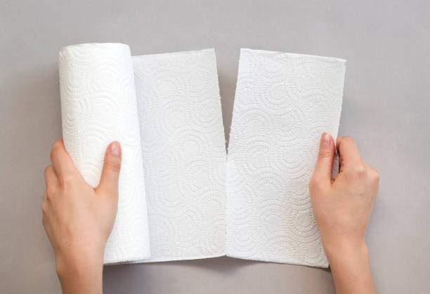 istock Hand holding white paper towel roll 1164790595