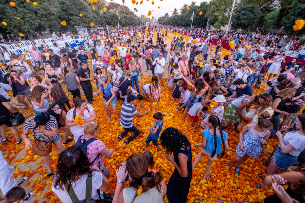 The public plays with the flowers that have been left over in the traditional parade of the Battle of the Flowers of Valencia. stock photo