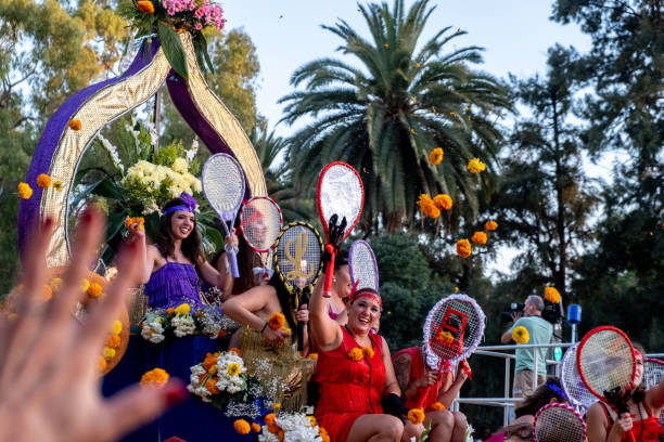 Disguised women play to throw flowers with the public from a float in the parade of the Battle of the Flowers of Valencia. stock photo