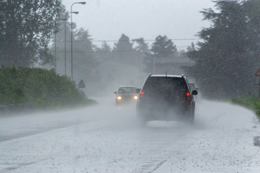 La fuerte tormenta con fuertes lluvias en la carretera con poca visibilidad de los coches. Concepto del peligro de conducir con mal tiempo photo