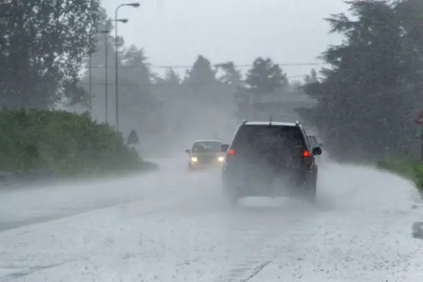 Photo of The strong storm with heavy rain on the road with poor visibility of cars. Concept of the danger of driving in bad weather