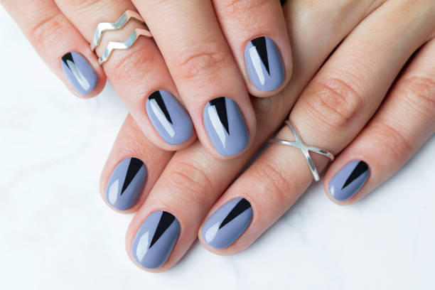 istock Two female hands with creative minimal manicure at white marble 1164798679