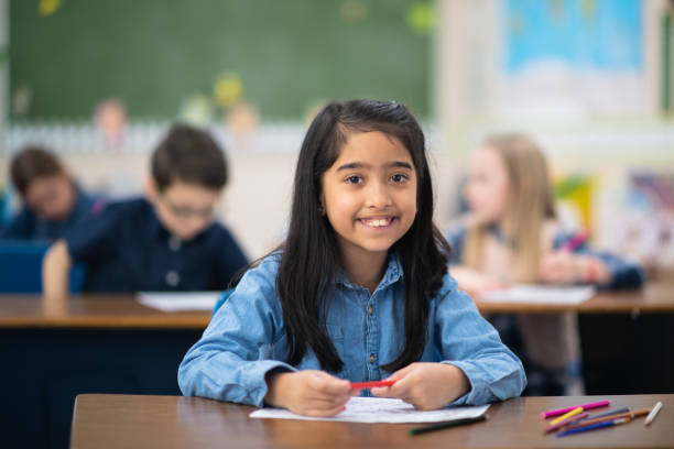 istock Cute little girl colouring in class 1164801529