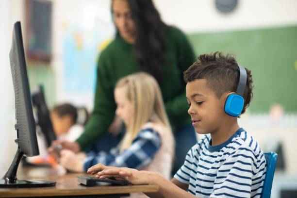 istock Male student wearing headphones in a computer lab 1164801547