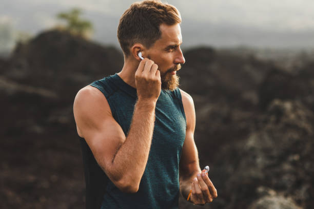 Man using wireless earphones air pods on running outdoors. Active lifestyle concept. stock photo