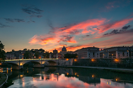 Rome cityscape at sunset with view of St Peters Basilica in Vatican and picturesque sky on the background. Rome, Italy
