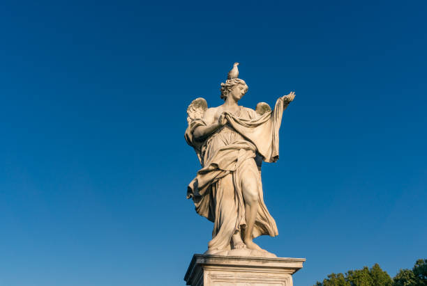 istock Statue of angel with bird sitting on its head 1164802517