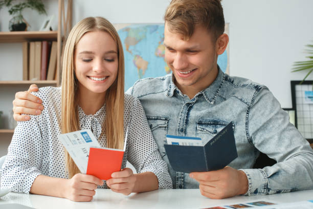istock Young couple in a tour agency travelling concept holding documents 1164802576