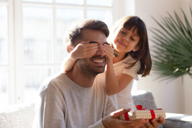 istock Little kid make birthday surprise to happy young dad 1164802813