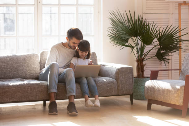 istock Happy young dad relax using laptop with preschooler daughter 1164802823