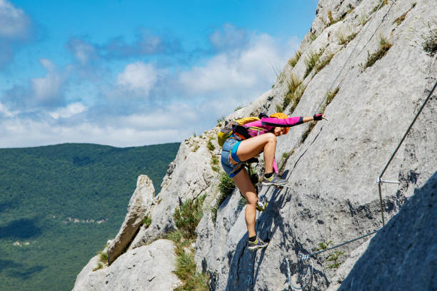 istock Woman climbing mountain. 1164802947