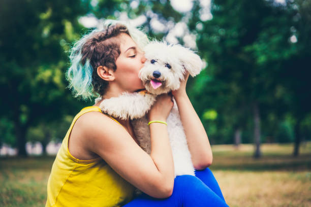 genç kadın köpeği dışarıda öpüyor. - kaniş stok fotoğraflar ve resimler