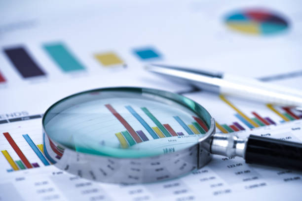 Magnifying glass on charts graphs spreadsheet paper. Financial development, Banking Account, Statistics, Investment Analytic research data economy, Stock exchange trading, Business office company meeting concept. Magnifying glass on charts graphs spreadsheet paper. Financial development, Banking Account, Statistics, Investment Analytic research data economy, Stock exchange trading, Business office company meeting concept. bar graph photos stock pictures, royalty-free photos & images