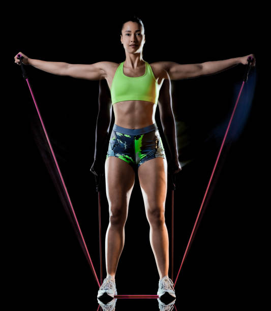 woman exercising fitness exercises isolated black background lightpainting effect one mixed race woman exercising fitness exercises isolated on black background with lightpainting effect multiple exposures lightpainting stock pictures, royalty-free photos & images