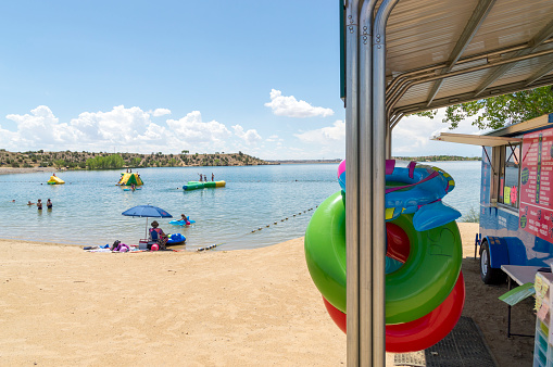 This photo was taken at Farmington Lake in Farmington, New Mexico.  This is a public lake with an area dedicated to swimming and playing with water toys.  A food stand and equipment rental shop is located next to the swimming area.