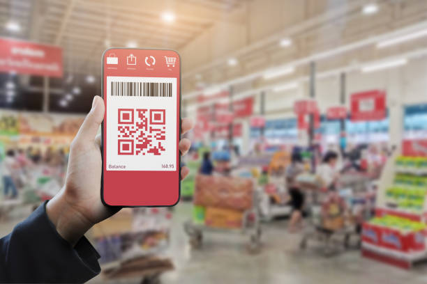 istock Hand holding a smartphone showing qr code or e-wallet at supermarket. Mobile QR code payment and e-wallet concept. 1164823241