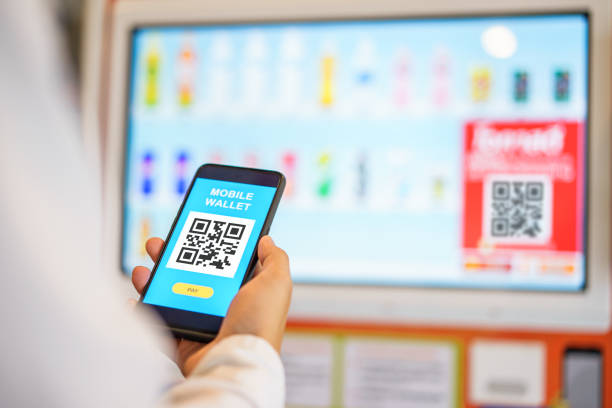 istock Attractive young male hands using mobile smartphone making payment on vending machine. Mobile wallet payment concept.selective focus 1164823491
