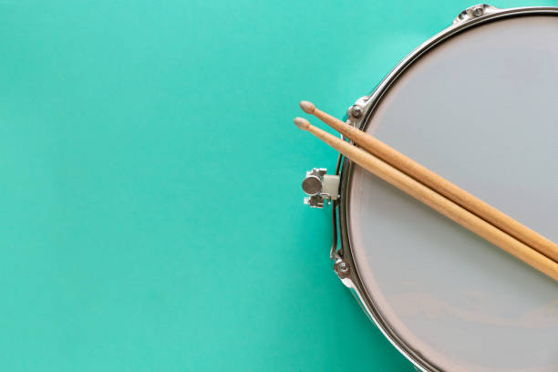 istock Drum and drum stick on green table background, top view, music concept 1164826356