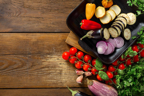 istock Various vegetables for cooking on grill pan on wooden background top view copy space 1164827309