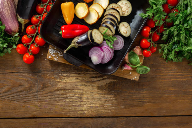 istock Various vegetables for cooking on grill pan on wooden background top view copy space 1164827336