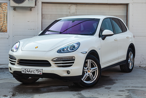 Novosibirsk, Russia - 07.25.2019: Front view of Porsche Cayenne 958 2008 in white color after cleaning before sale in a summer day on parking background