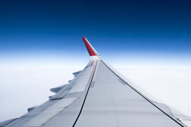 istock Wing of an airplane flying above the ocean. 1164832028