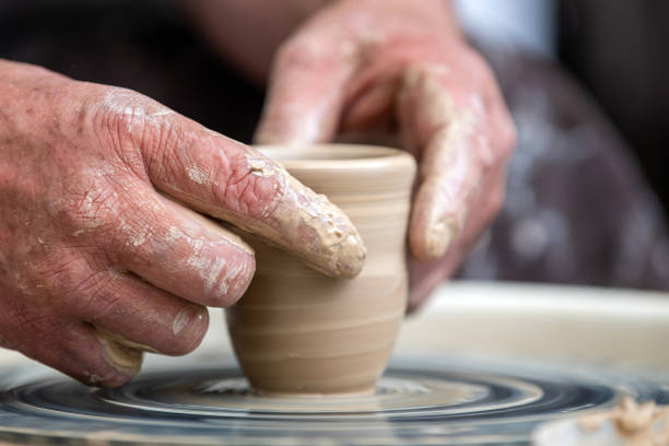 istock Potter makes pottery dishes on potter's wheel 1164832906