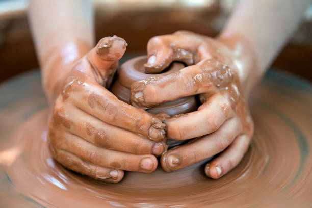 istock Potter makes pottery dishes on potter's wheel 1164832946