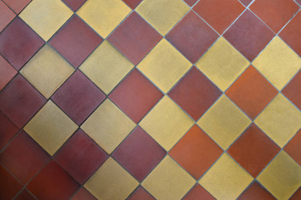 istock Old shabby square ceramic floor tiles (mettlach tiles). Diagonal chequered pattern. Top view. 1164834014