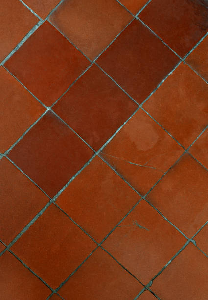 istock Old shabby square monochromatic brown ceramic floor tiles (mettlach tiles). Diagonal pattern. Top view. 1164834036