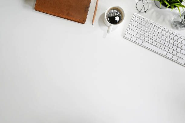 istock Office desk computer keyboard, coffee, pencil and book with copy space top view table. 1164836959