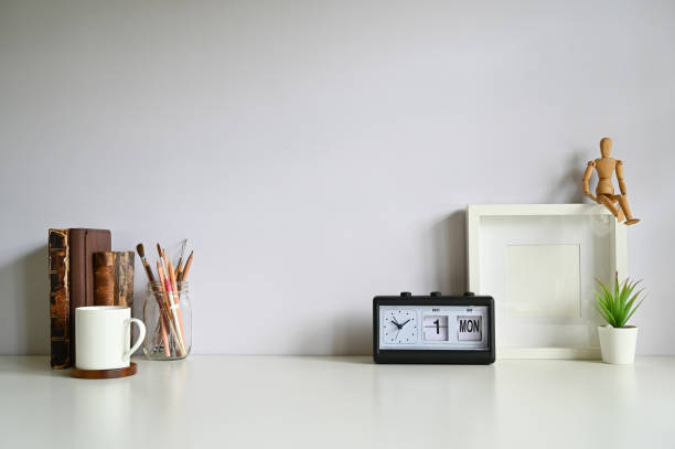 istock Workspace photo frame, coffee, alarm, books with plant decorate on white table. 1164837088