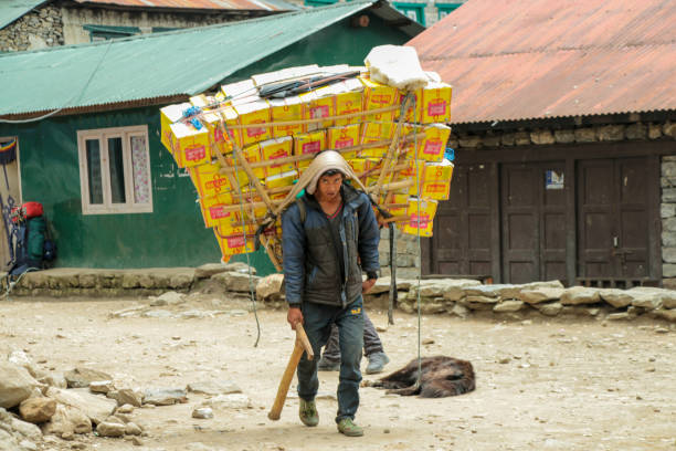 sherpa porter carrying a heavy load in nepal - lukla imagens e fotografias de stock