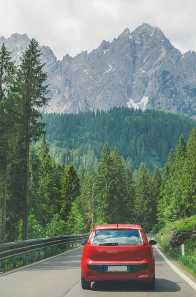 istock small red car on the road through mountains road trip 1164841558