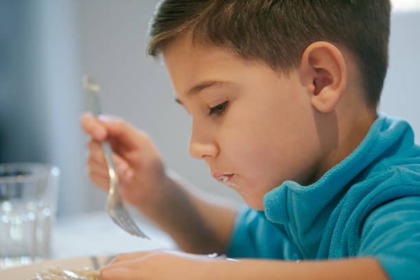 istock Boy eating pasta in sauce 1164842655