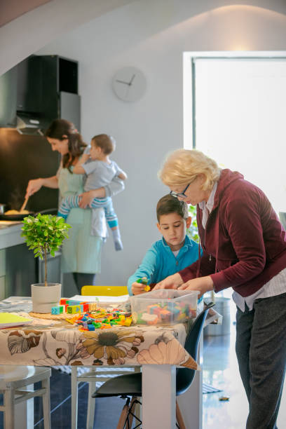 istock Boy playing with toy blocks by the table with grandmother 1164842729
