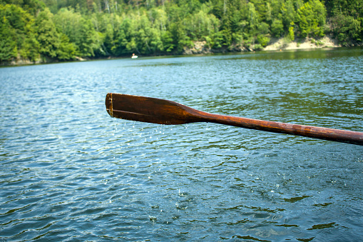 Oar of paddle boarder half way submerged in water paddling