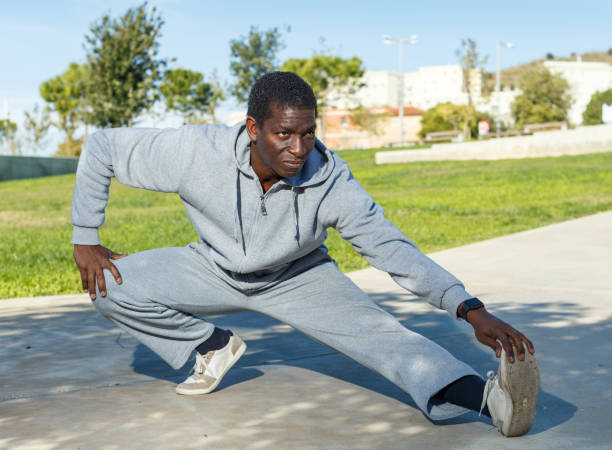 istock Athletic young male in sportswear training different exercises at park 1164845991