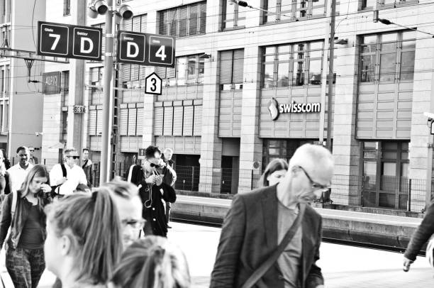 недавно прибывшие швейцарские пассажиры на платформу железнодорожного вокзала делемонт - швейцария. делемон�т —столица швейцарского кант� - swisscom стоковые фото и изображения