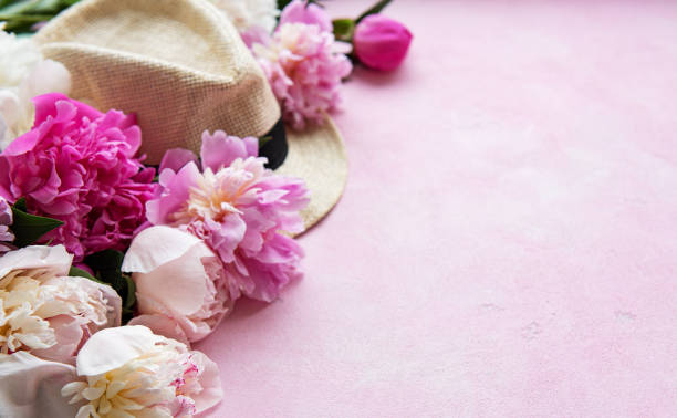 istock Pink peonies and hat on a pink concrete background 1164848941