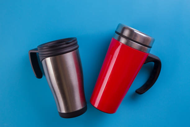 two thermomugs on blue background. winter time concept
