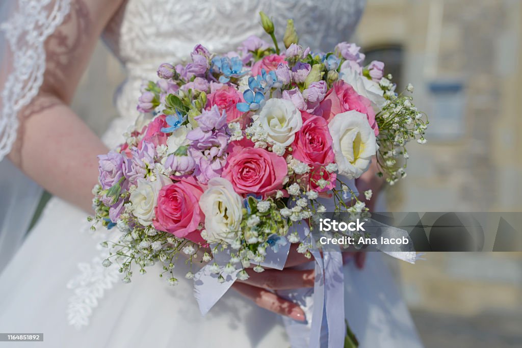 Novia joven con clase en la ceremonia de la boda con el foco en la mano sosteniendo un arreglo floral - Foto de stock de Ceremonia Matrimonial libre de derechos